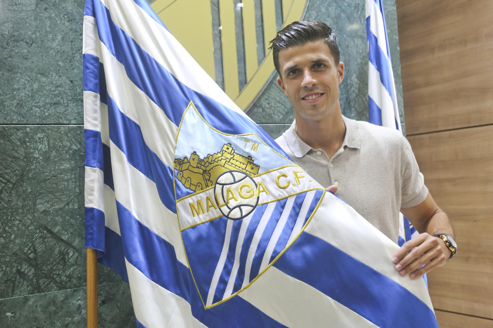 Héctor Hernández posa con la bandera del Málaga.