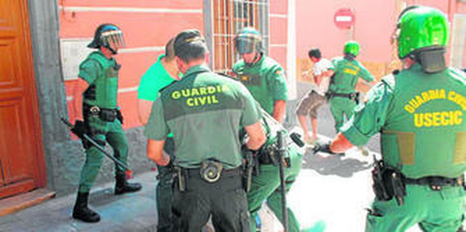 Agentes de la Guardia Civil reducen a la fuerza a varios familiares y vecinos que se colaron en el juzgado con la intención de agredir al presunto asesino.