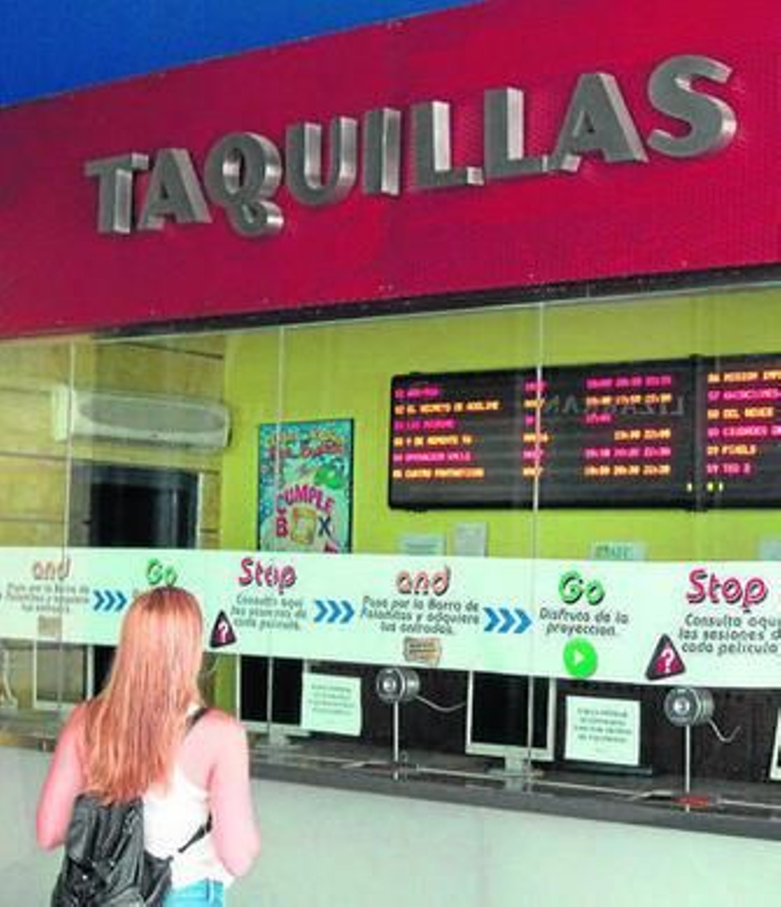 Una chica consulta la cartelera en las taquillas de los cines Aqualon.