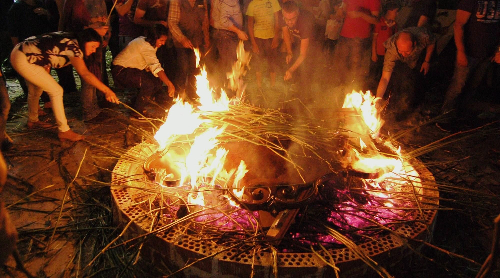 Vecinos crujen los gamones alrededor de una de las candelas