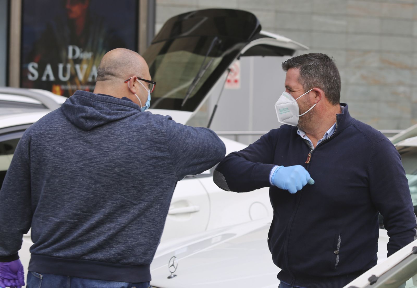 Dos personas se saludan con el codo