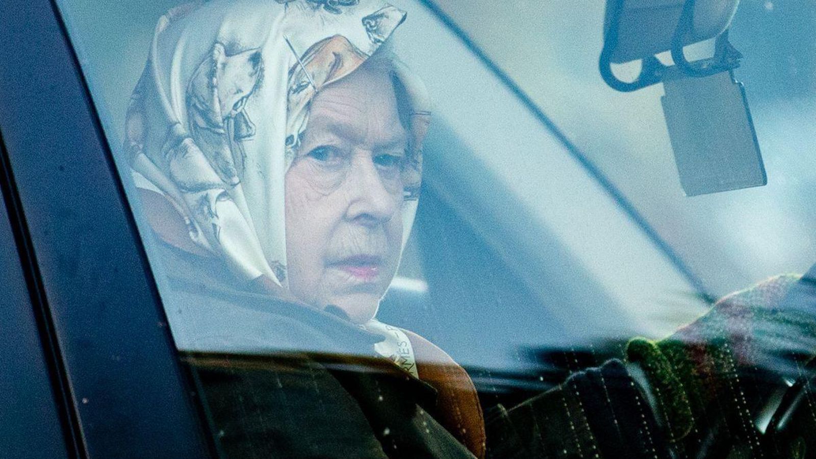 Isabel II mira a los paparazzi desde su coche.