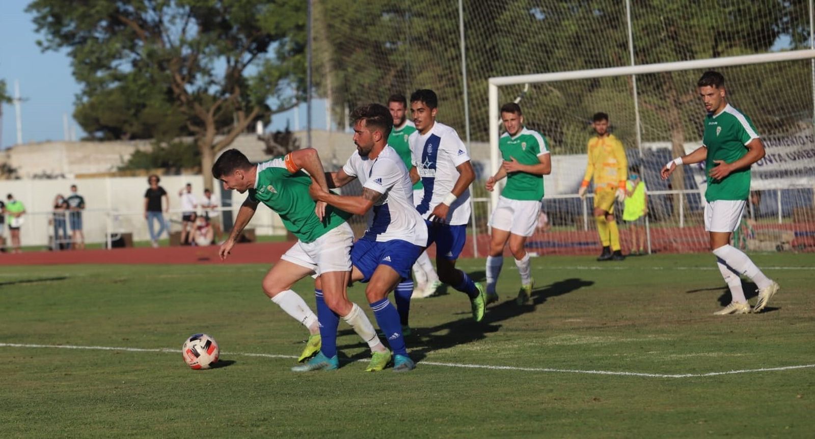 Javi Flores es agarrado por un jugador del Recreativo de Huelva en el amistoso disputado en Punta Umbría.