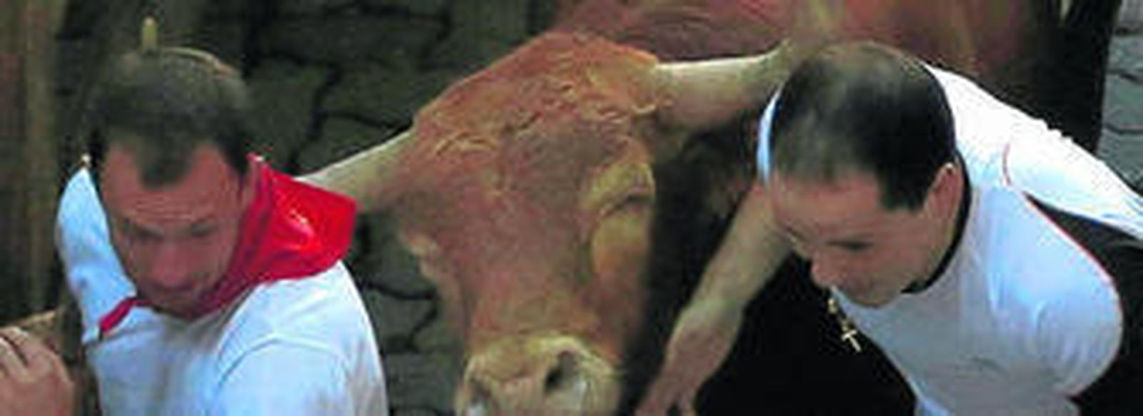 Dos mozos libran la acometida de un toro de Alcurrucén.