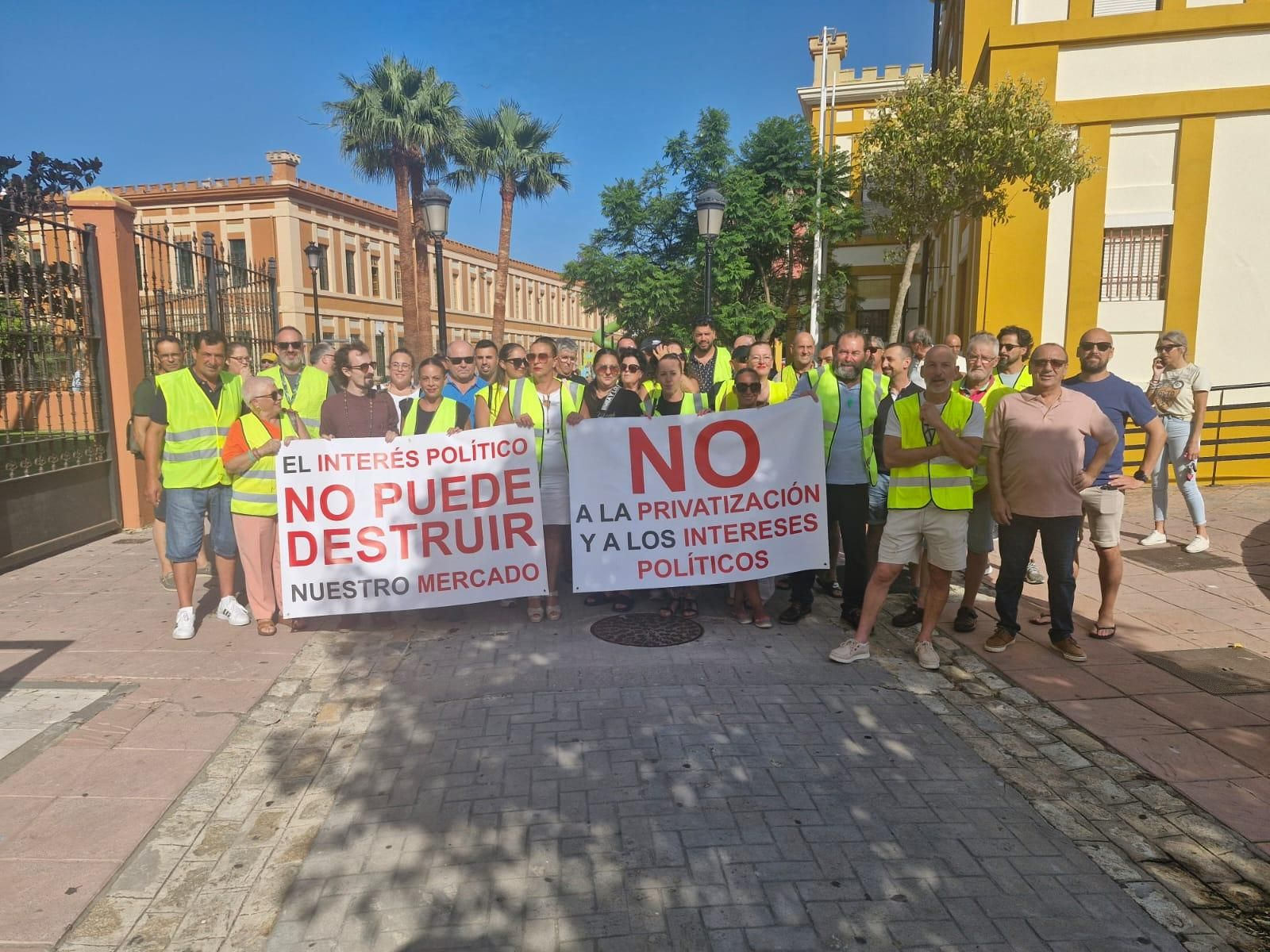 Comerciantes y miembros de la Flavi, con carteles contra la privatización.