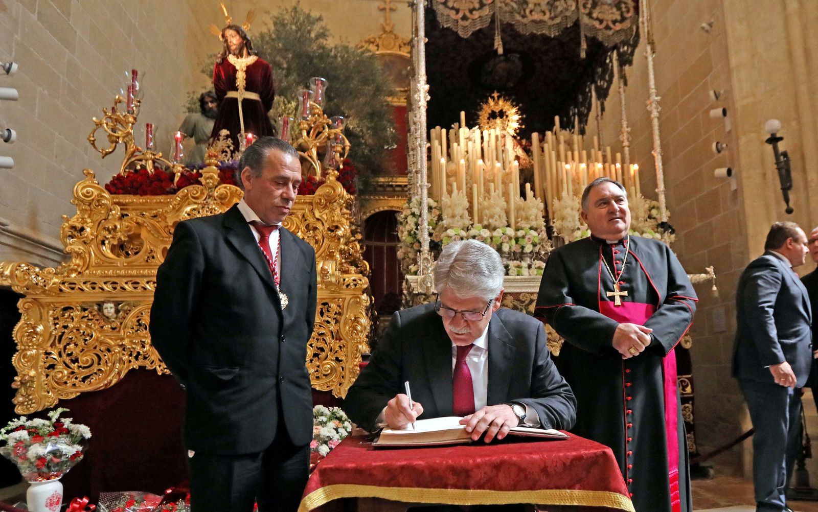 El ministro Alfonso Dastis firmando junto al ex hermano mayor y el obispo José Mazuelos el pasado Miércoles Santo.