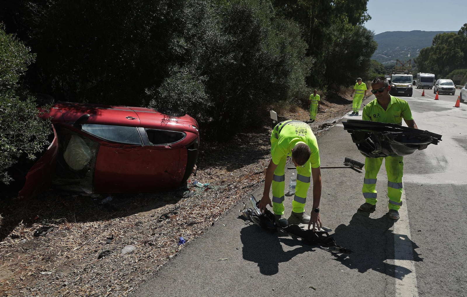 Los operarios recogen los restos de un coche accidentado en la N-340, el pasado verano.