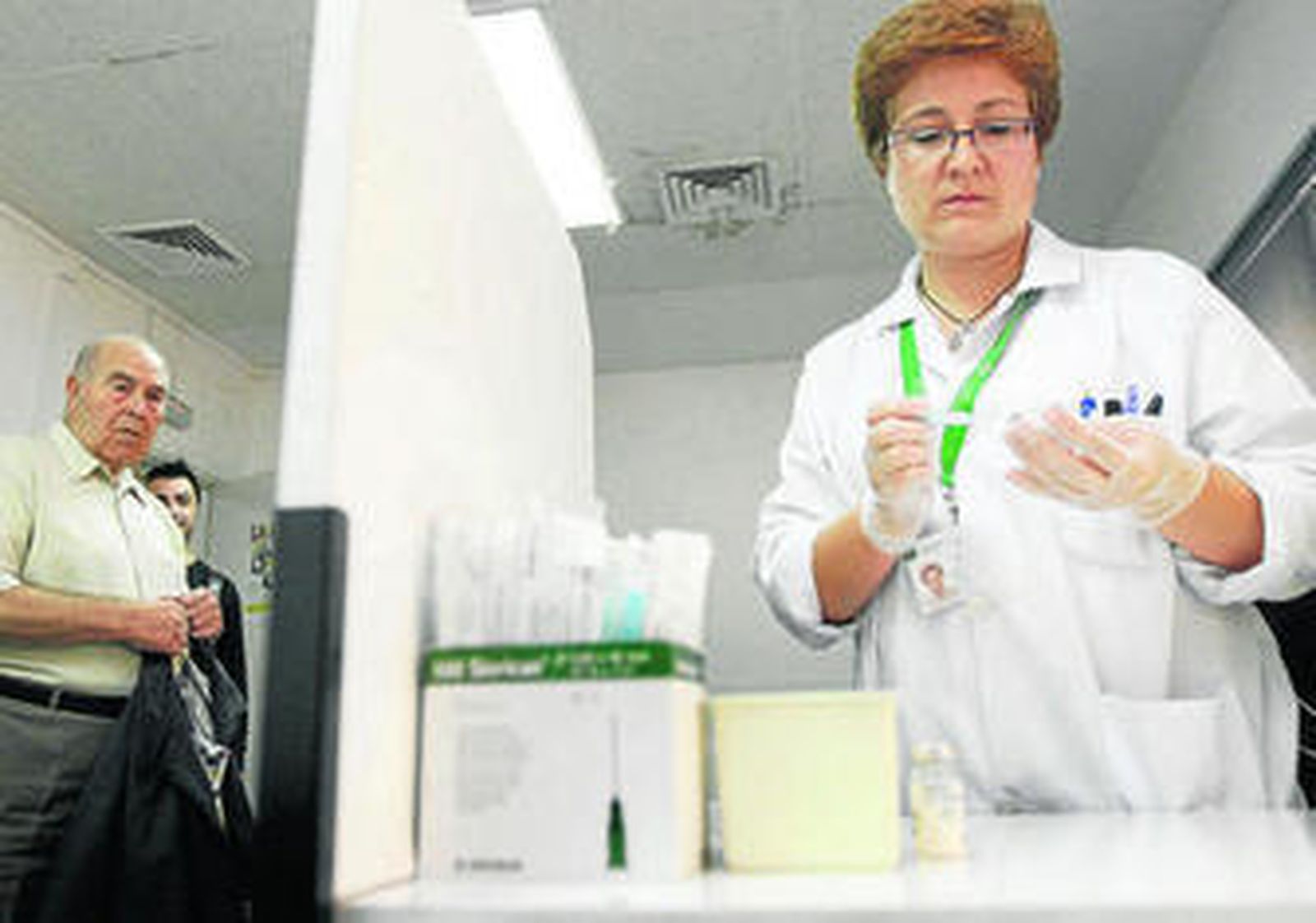 Una enfermera prepara la dosis para inyectar a un paciente.