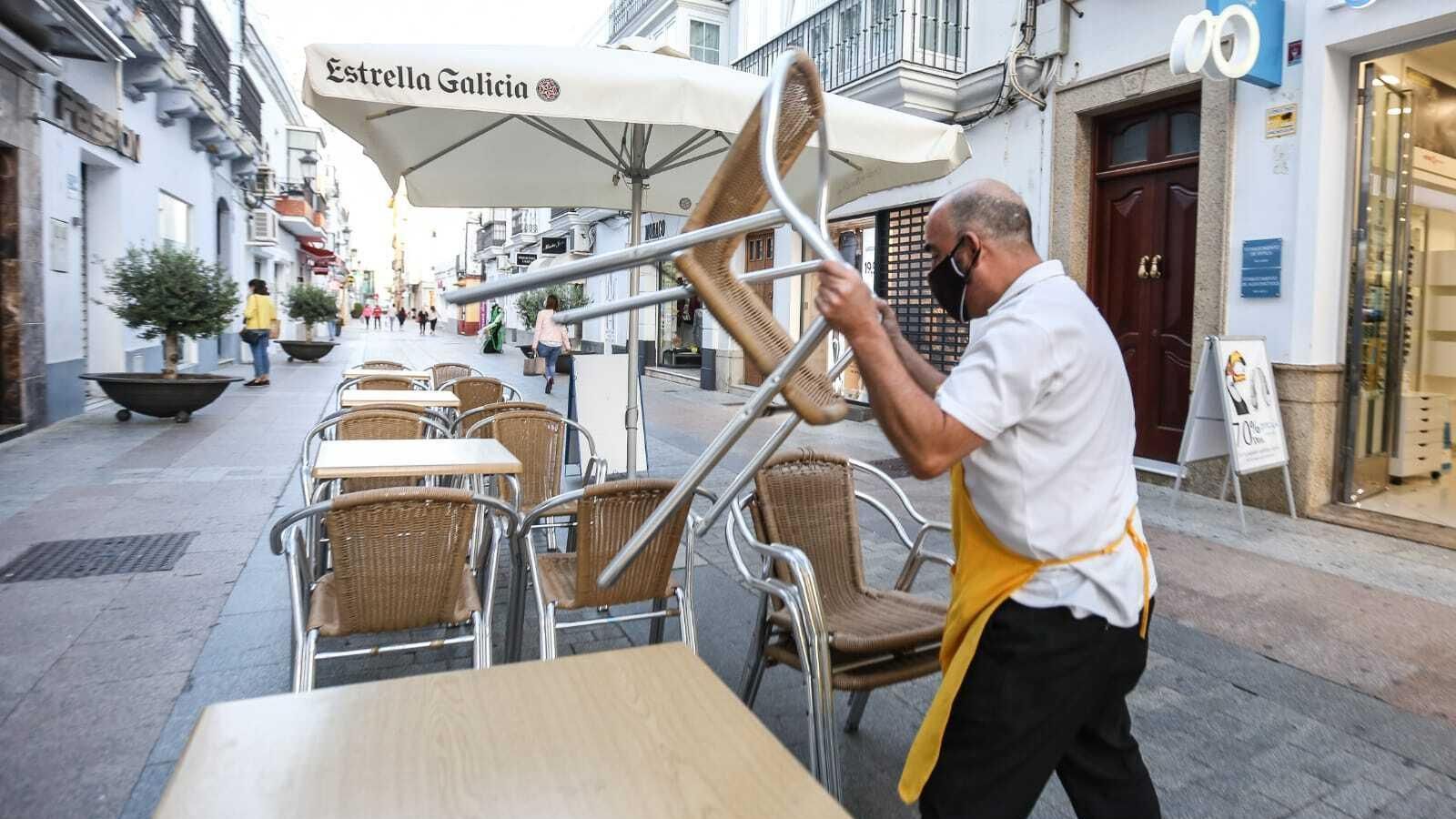 El encargado de una cafetería recoge la terraza.