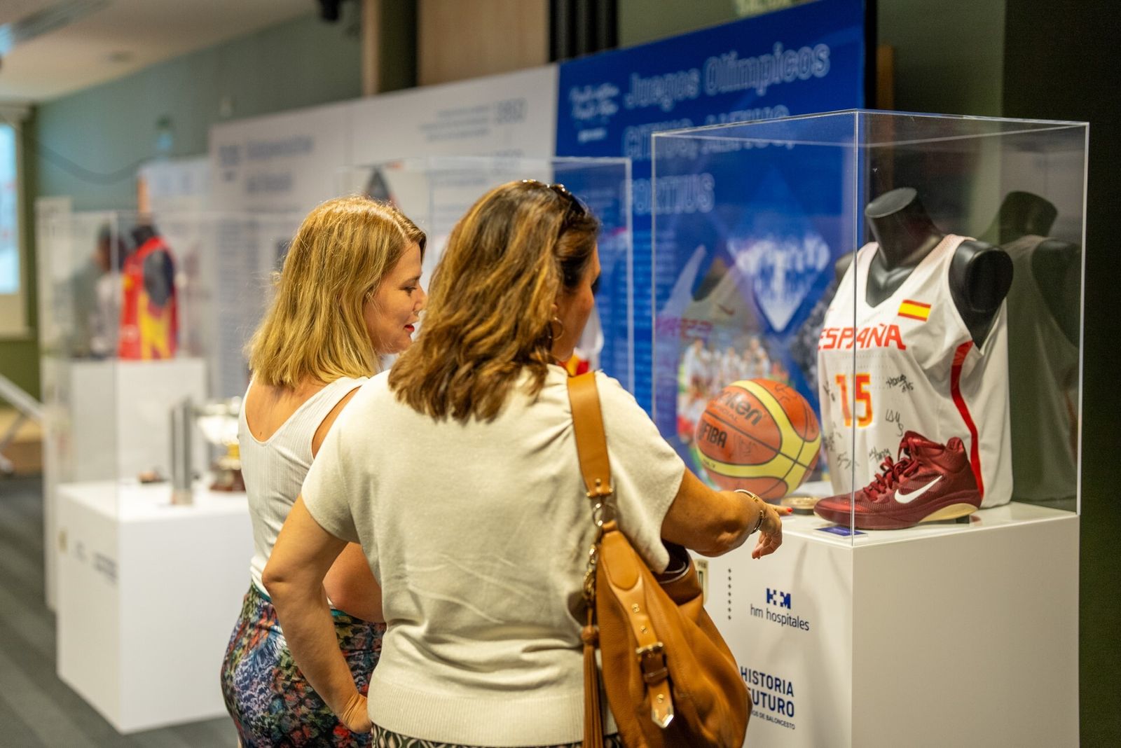 Dos visitantes en la exposición inaugurada en el Hospital HM Málaga sobre la historia del baloncesto español