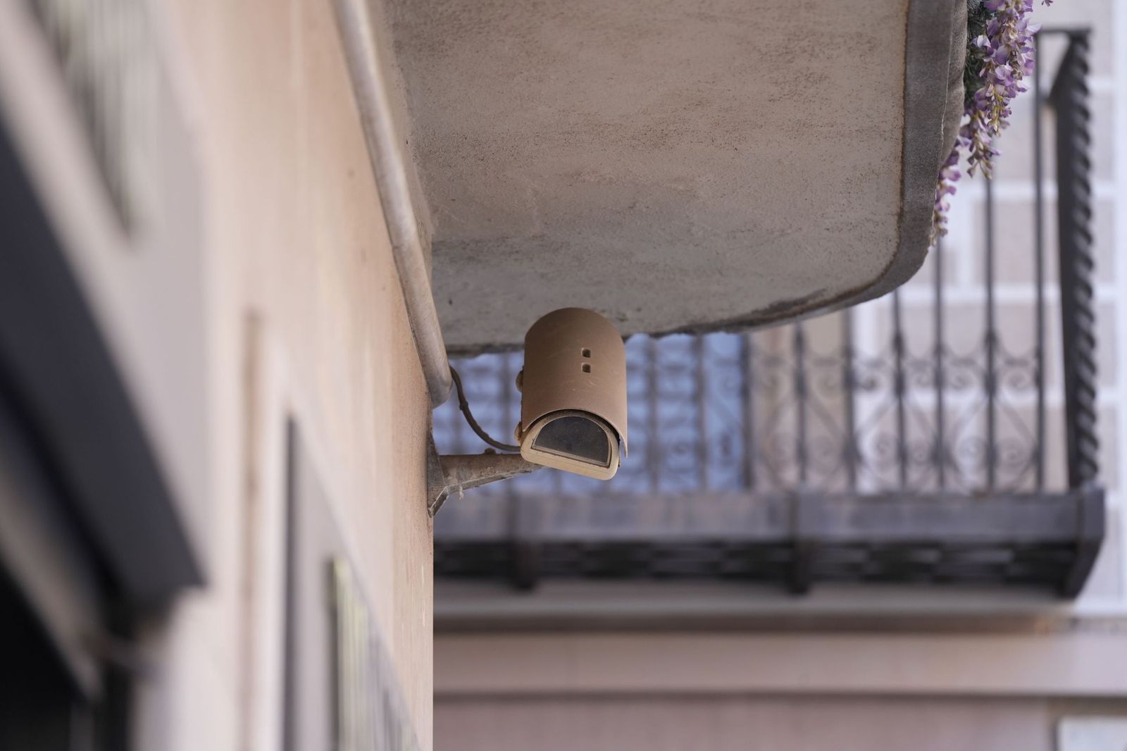 Una cámara de vigilancia orientada hacia la entrada de un edificio.