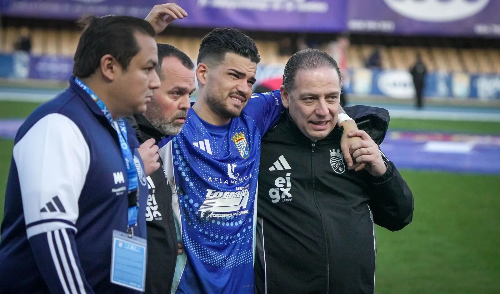 Zequi Díaz se retira del campo ayudado por el doctor David Zarco en el partido contra el Linares.