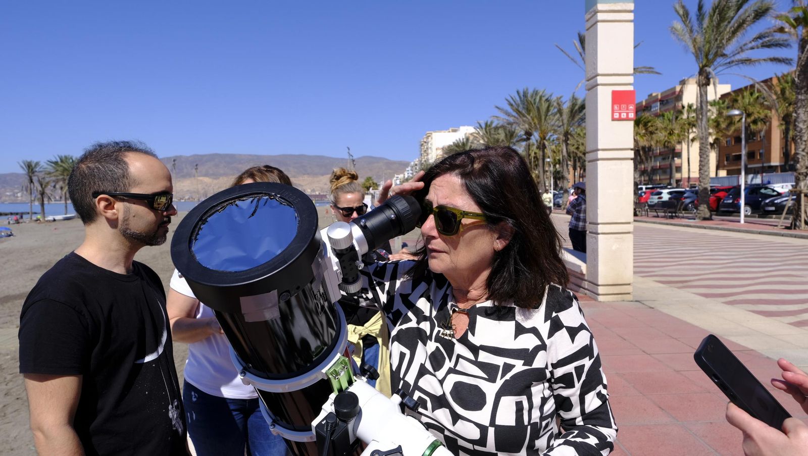 Almería observa el eclipse solar desde el Paseo Marítimo, en imágenes
