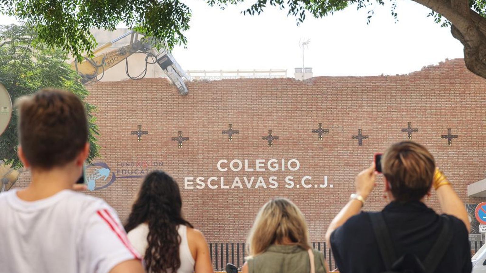 Vecinos contemplan la imagen del derribo de la fachada de Las Esclavas