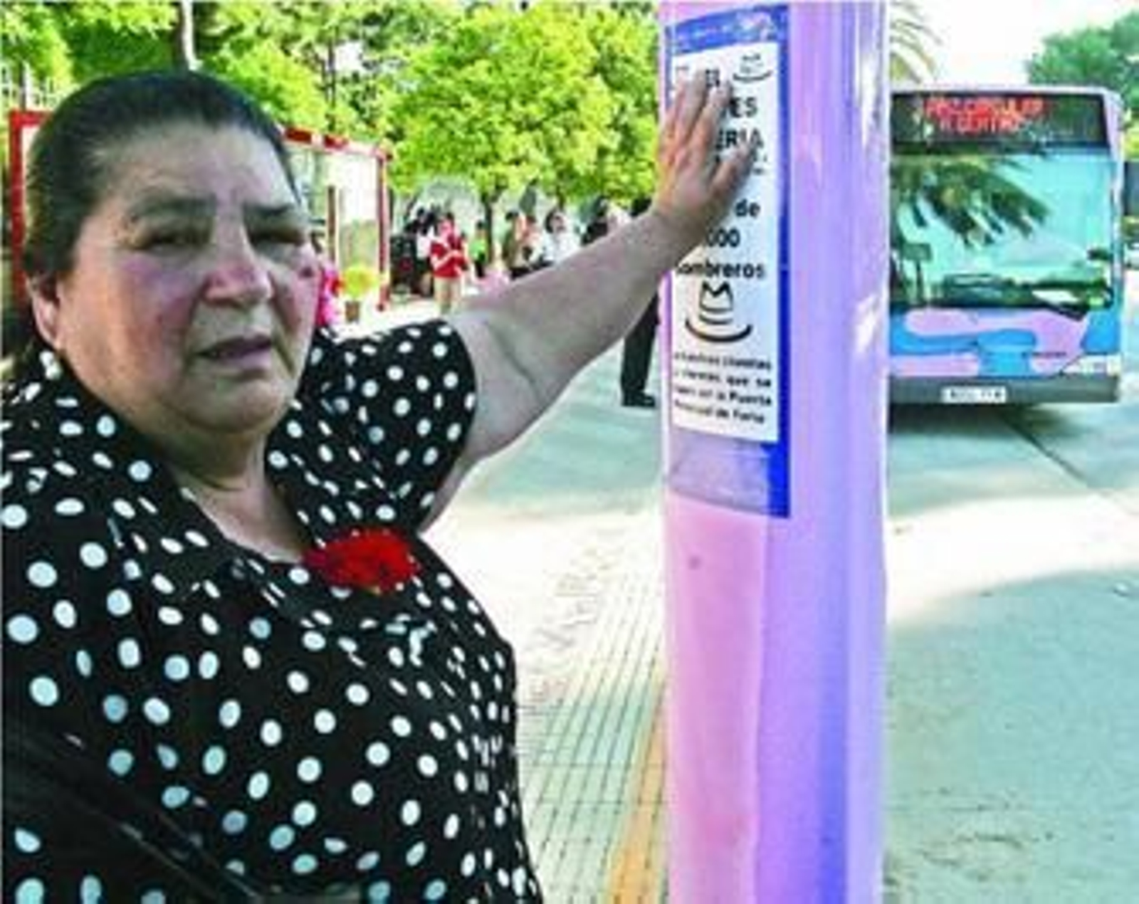 Una mujer espera, ayer, en una parada de autobús junto a la Feria.