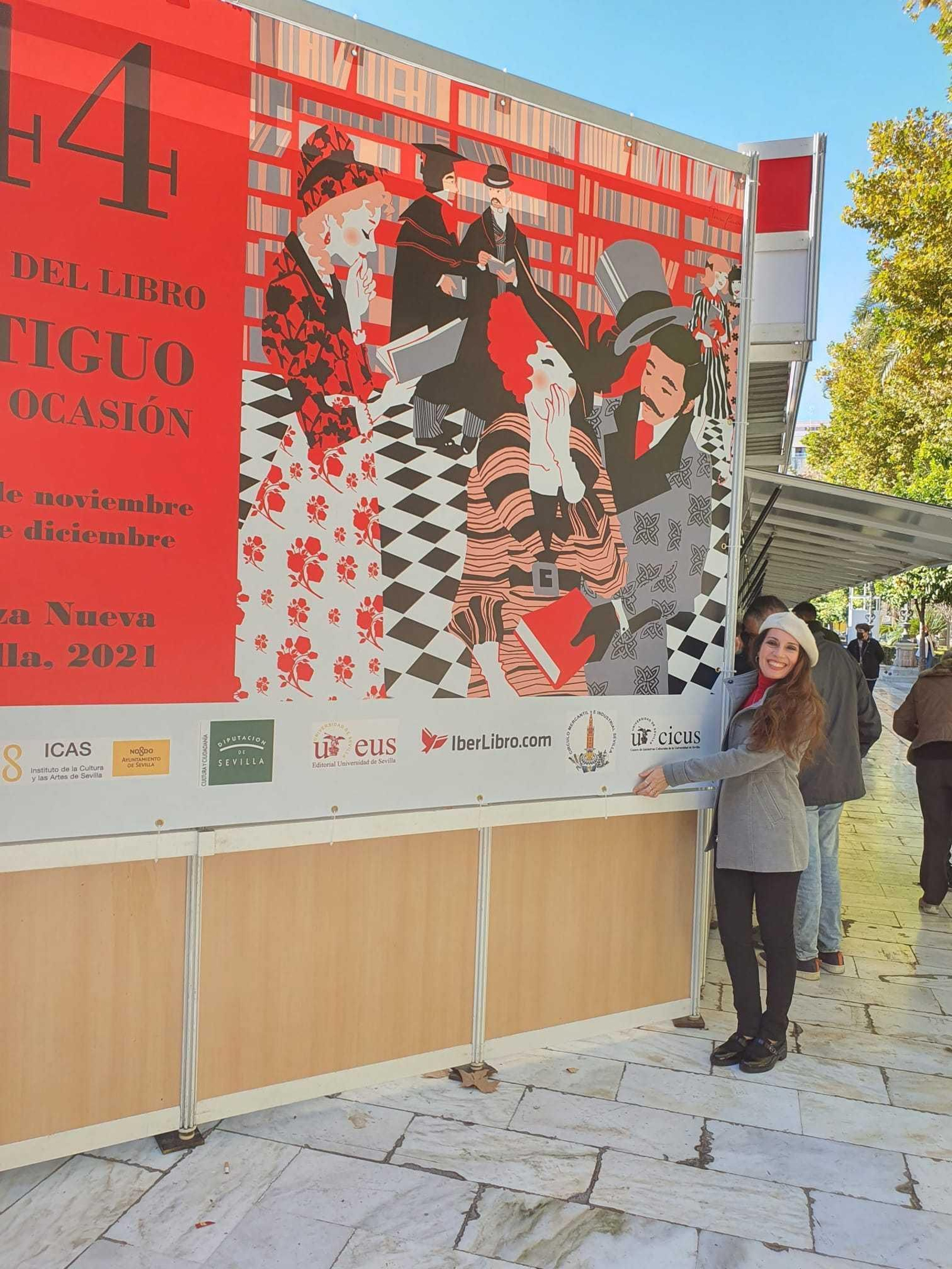 Teresa Guzmán posa junto al cartel de la Feria del Libro Antiguo y de Ocasión.
