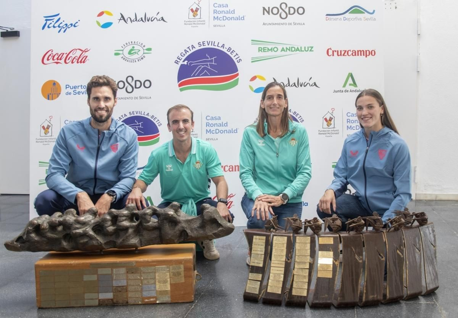 Representantes de ambos equipos posan con los trofeos.