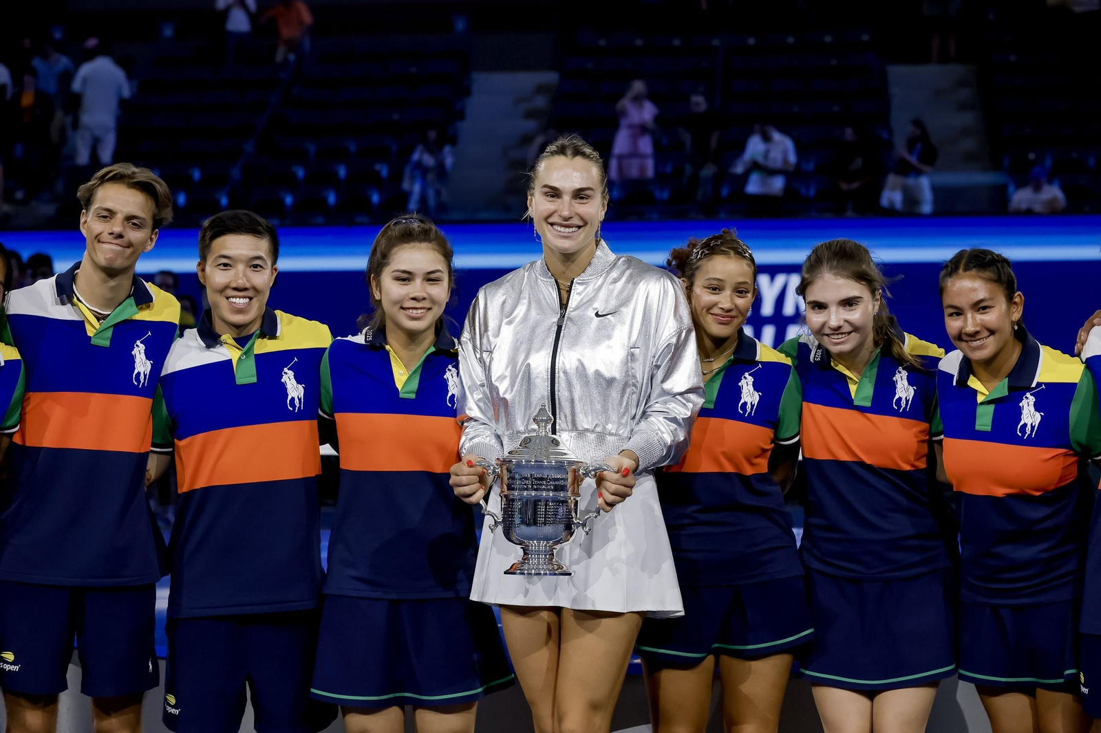 Aryna Sabalenka posa junto a los recogepelotas con su trofeo de campeona del US Open.