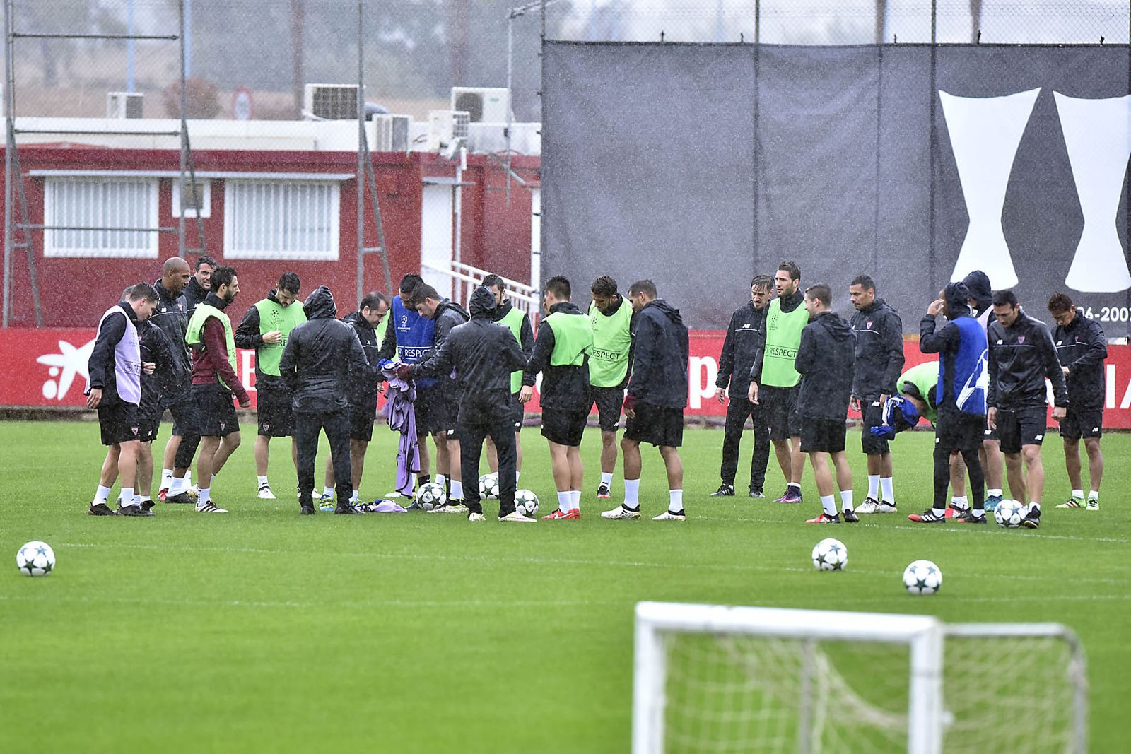 La plantilla sevillista, momentos antes de iniciar el entrenamiento de ayer bajo la lluvia en la ciudad deportiva.