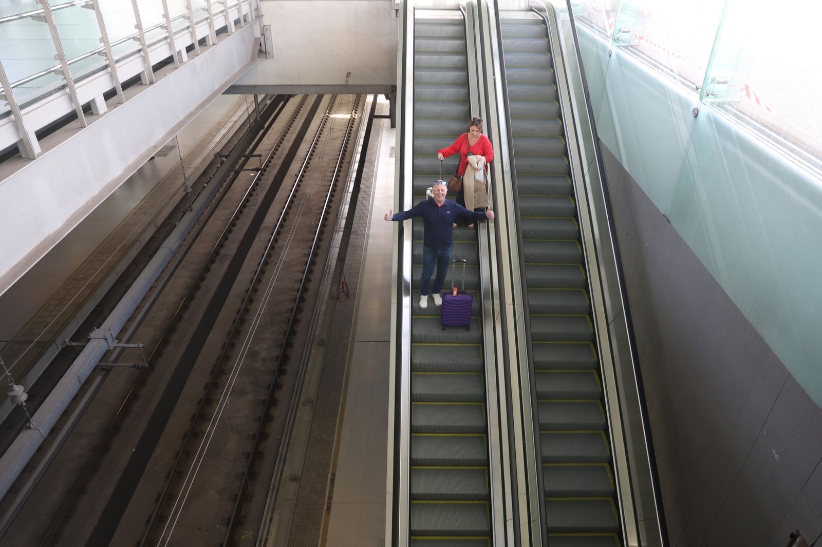 Un usuario muestra su felicidad con los pulgares arriba al usar la escalera del aeropuerto.