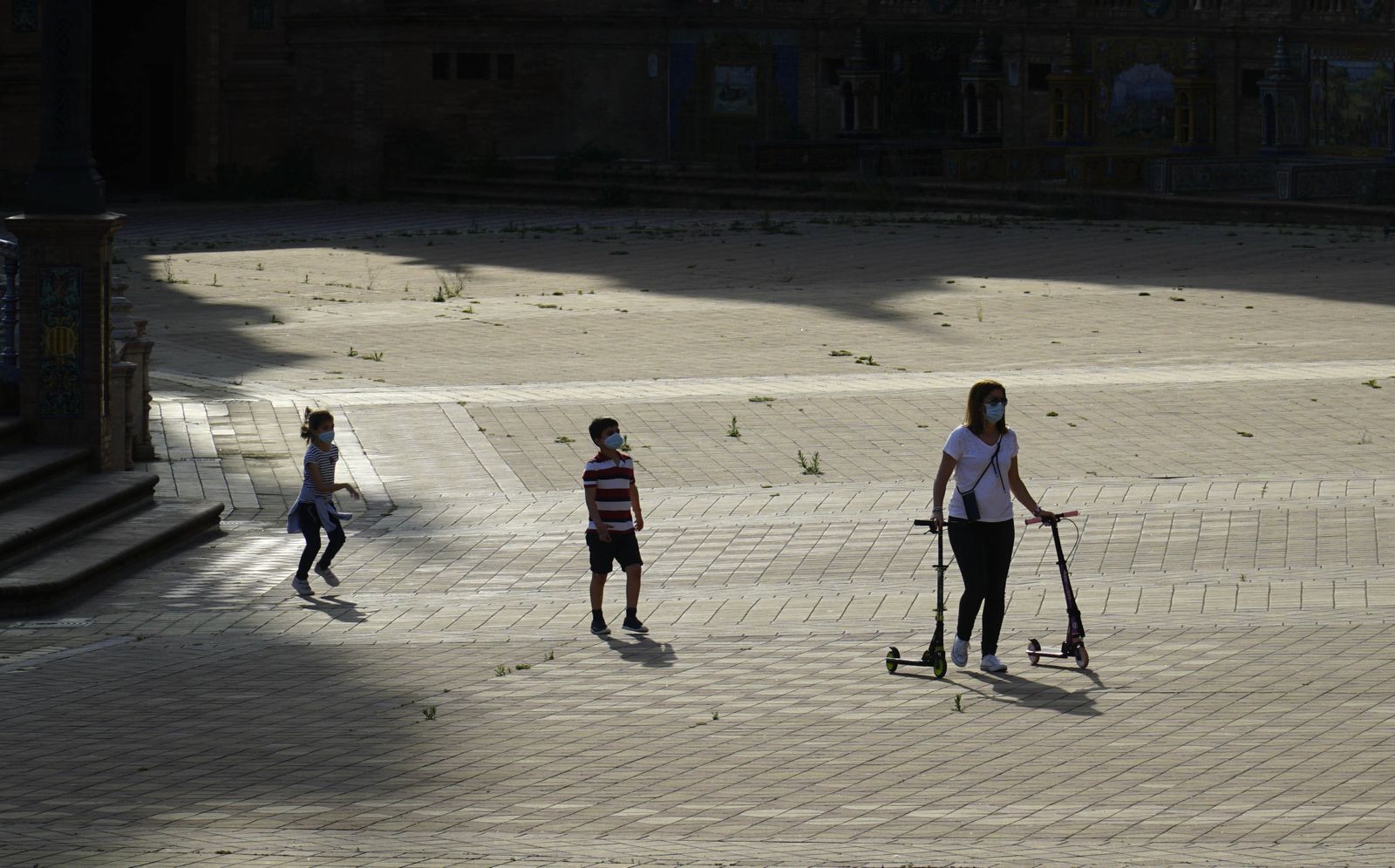 Una familia disfruta de un paseo en patinete por Sevilla.