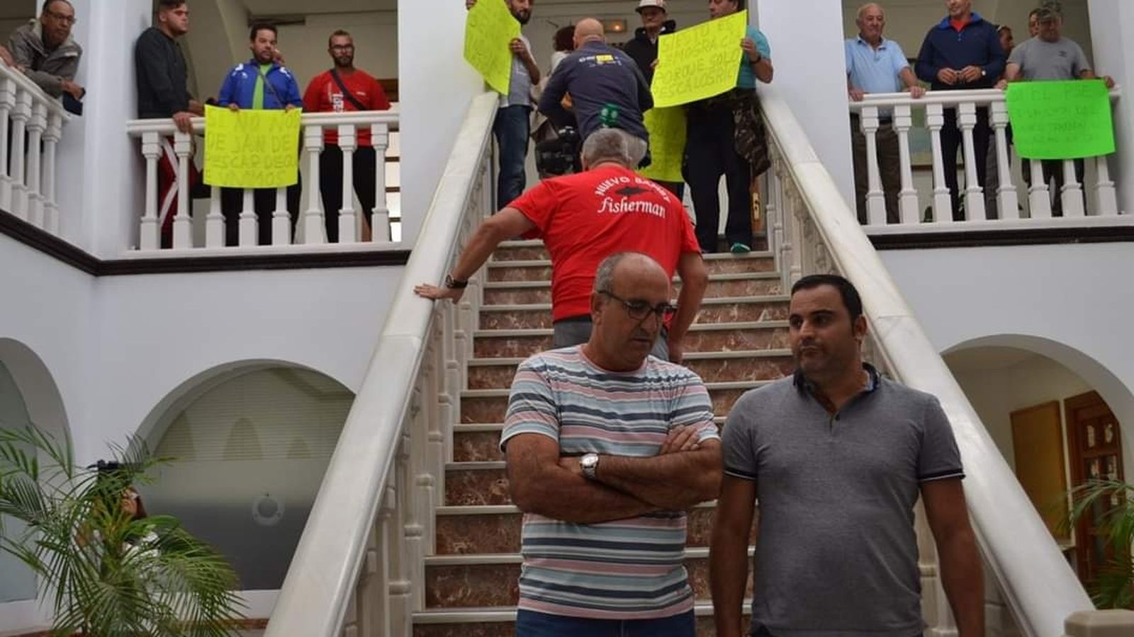 El patrón mayor de Tarifa, Manuel Suárez (d), conversa junto a un compañero en el Ayuntamiento de Tarifa.