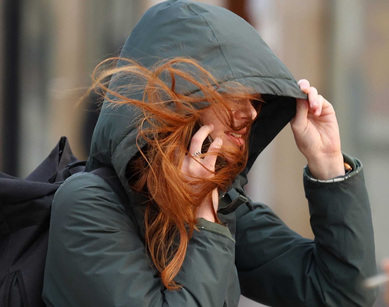 Una mujer, este viernes, se cubre por el fuerte viento que sopla en Málaga