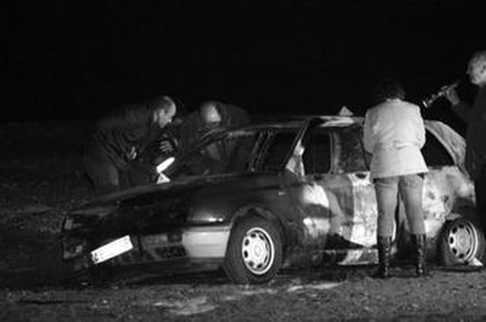 Agentes de policía analizan el vehículo calcinado, la madrugada del jueves en la playa de Motril.
