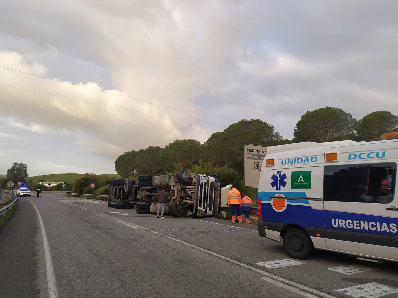 Efectivos sanitarios auxilian al camionero tras el vuelco.