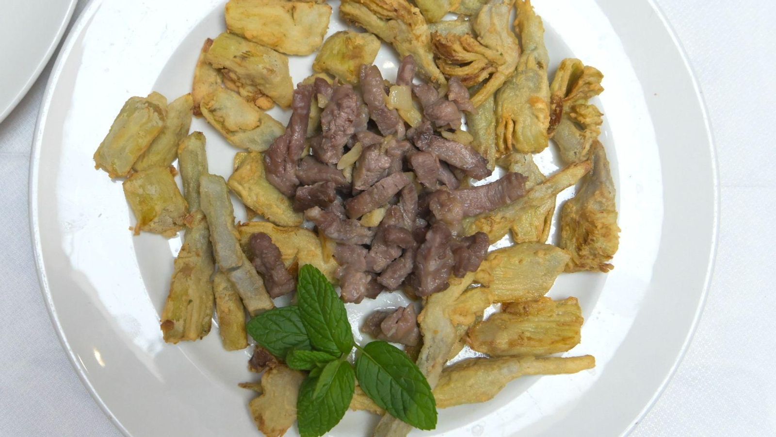 Alcachofas en tempura y salteado de lagarto ibérico.