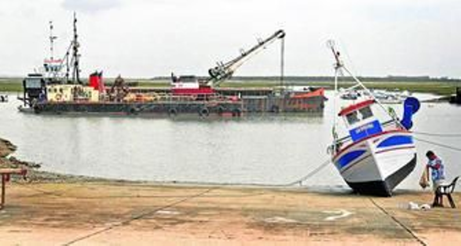 La draga trabajaba ayer frente al puerto pesquero de Sancti Petri.