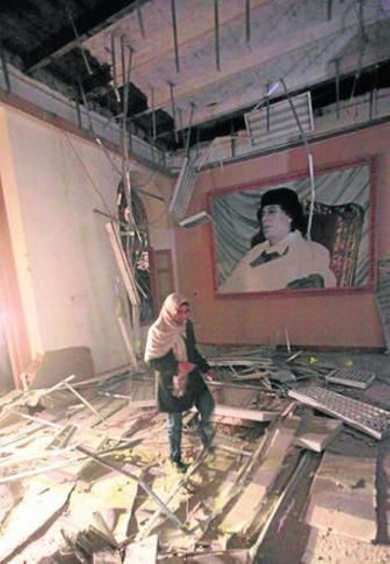 Una mujer contempla los destrozos en un edificio oficial de Trípoli.