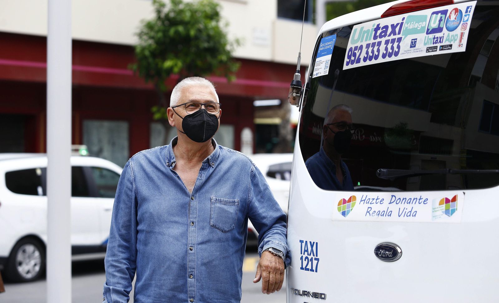 Antonio de los Ríos, en Málaga capital, junto a su taxi.