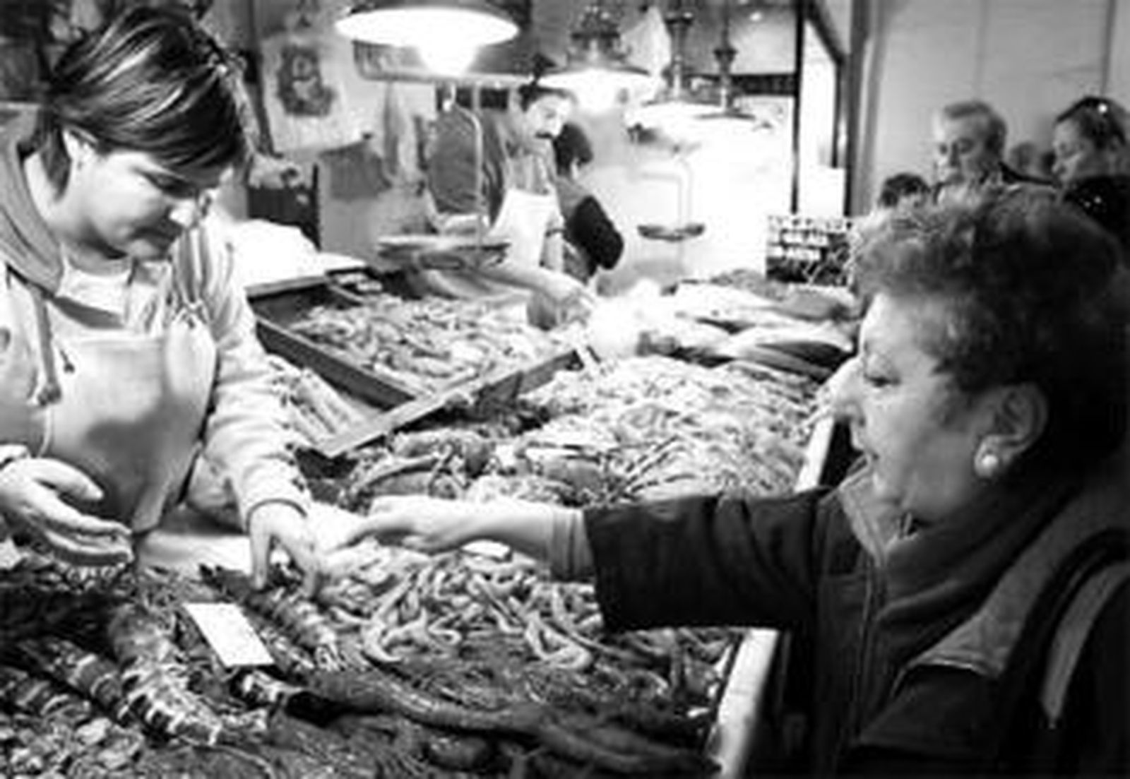 Una mujer compra marisco en un mercado de la capital.