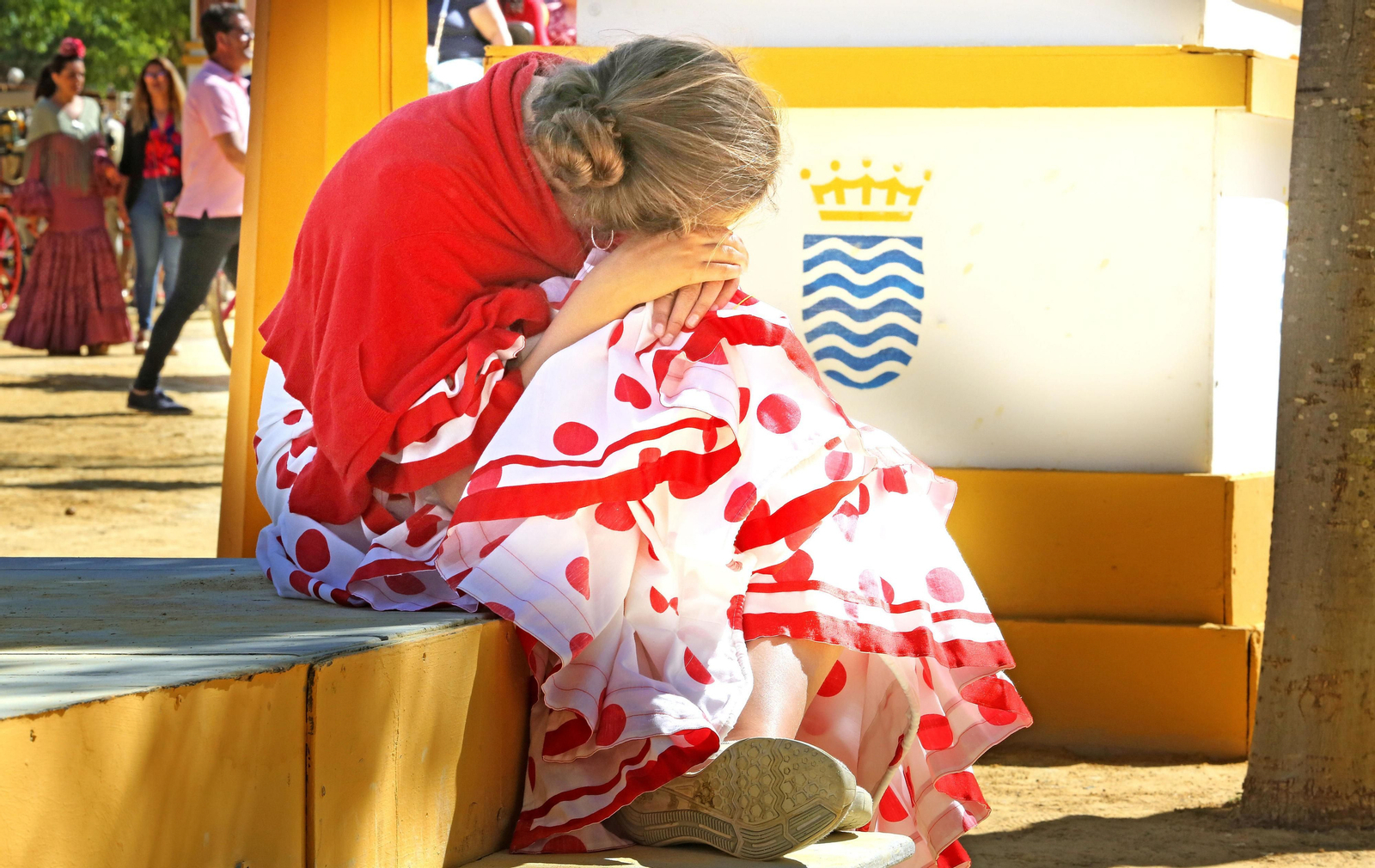 Una joven apoya su cabeza en sus rodillas en un signo de cansancio.