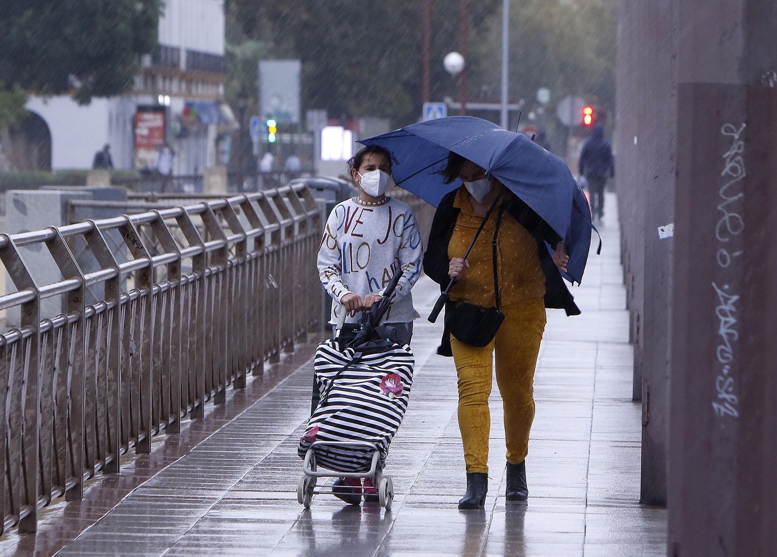 Dos personas bajo la lluvia en Sevilla.