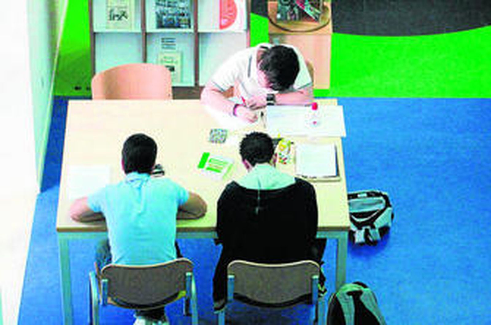 Unos jóvenes estudian en una biblioteca.