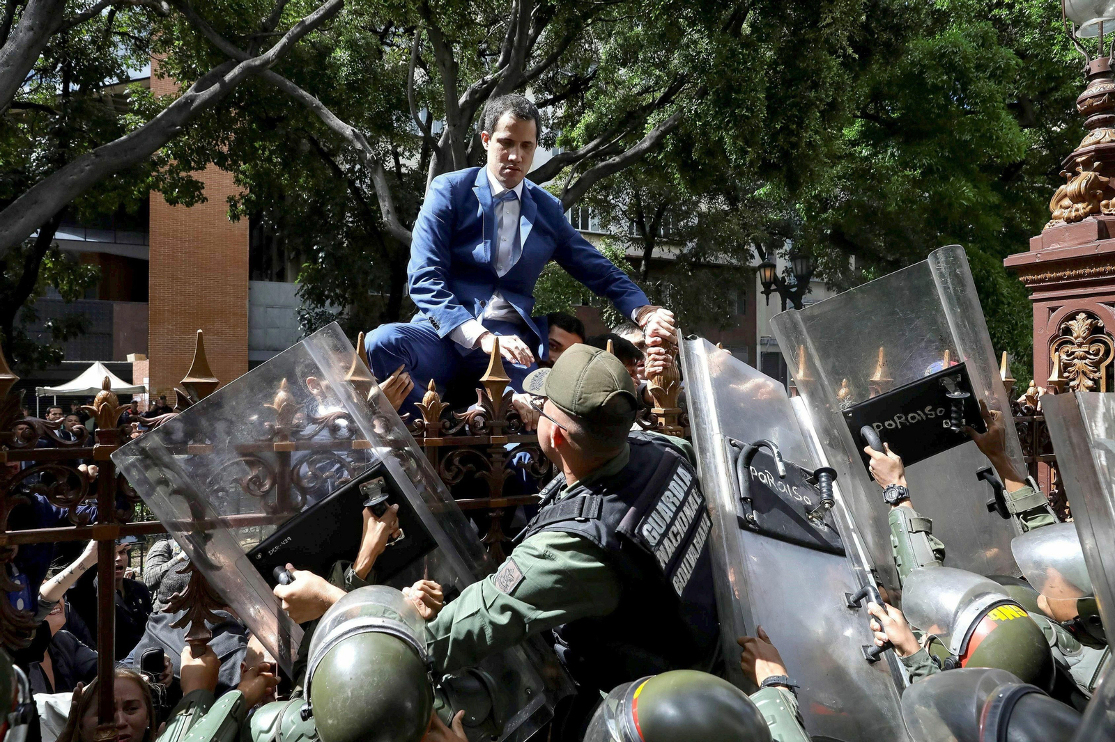 Guaidó, líder opositor a Maduro, se encarama a una verja para tratar de acceder sin éxito al Parlamento. Guaidó, líder opositor a Maduro, se encarama a una verja para tratar de acceder sin éxito al Parlamento.