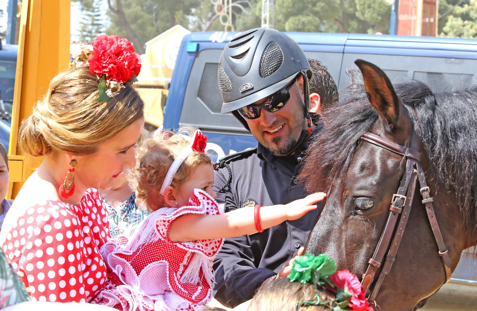 Una madre y su hija acarician un caballo de la Policía Nacional en el Real.
