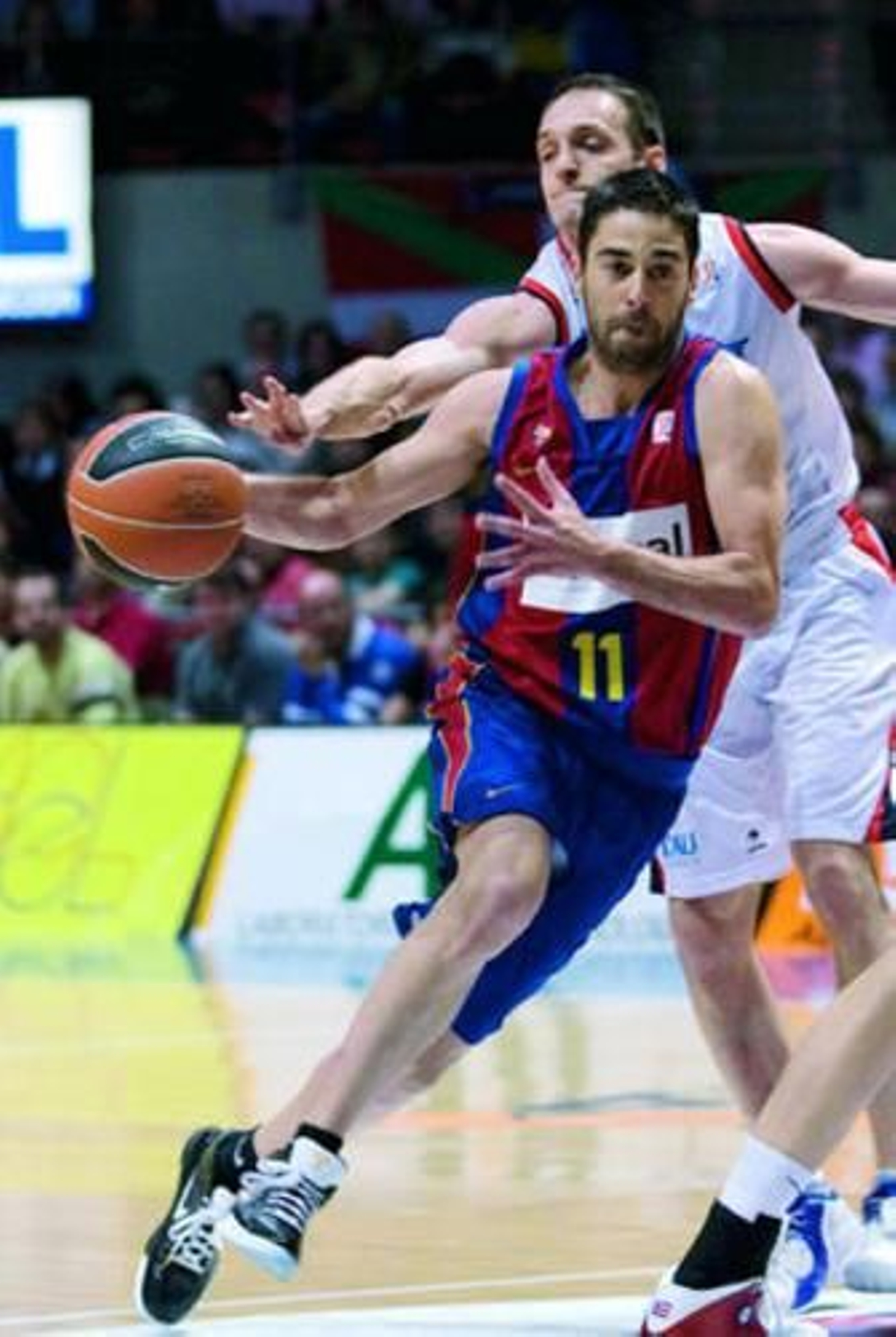 El baskonista Rakocevic trata de robar el balón por detrás al barcelonista Navarro.