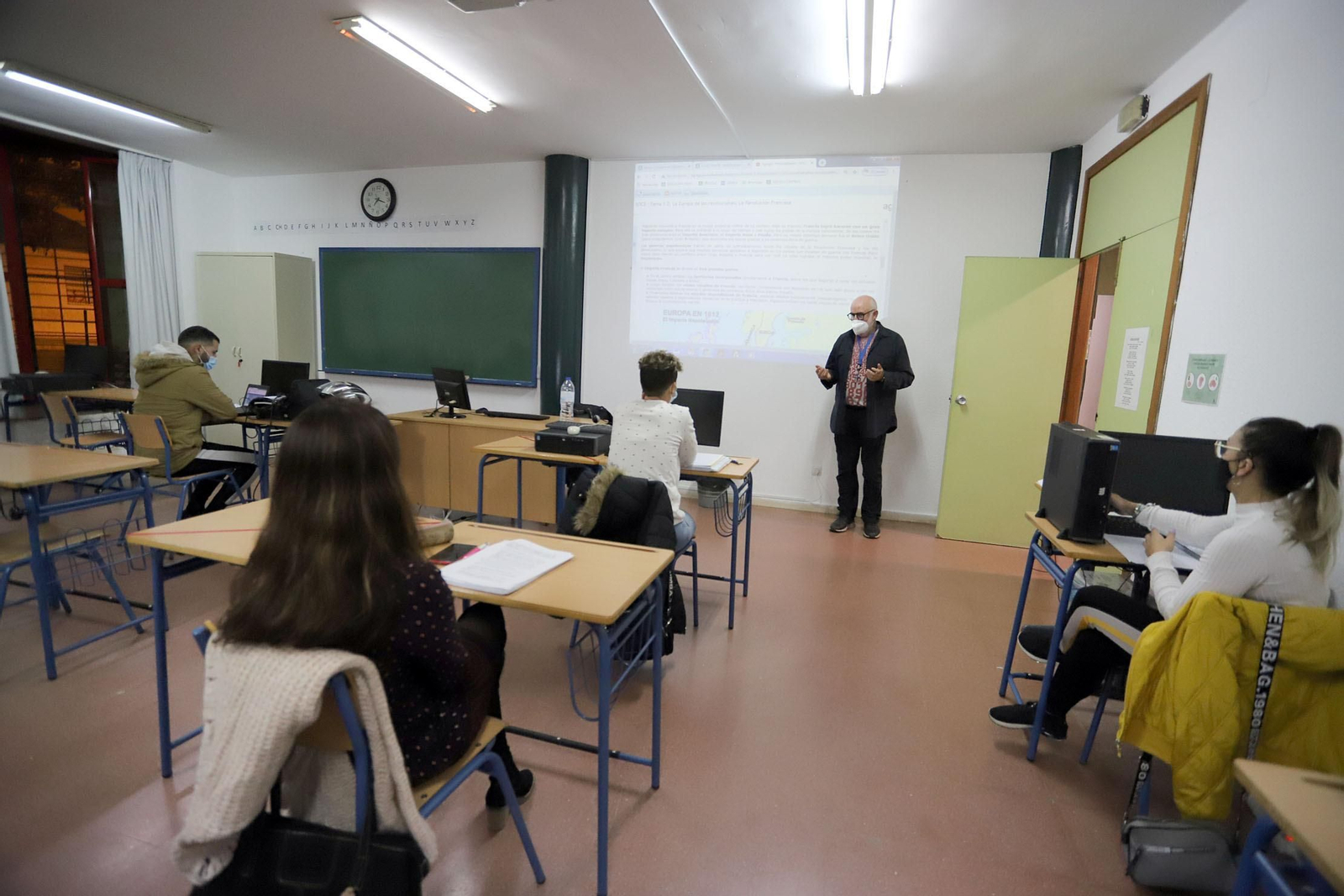 Alumnos atienden mientras explica el profesor