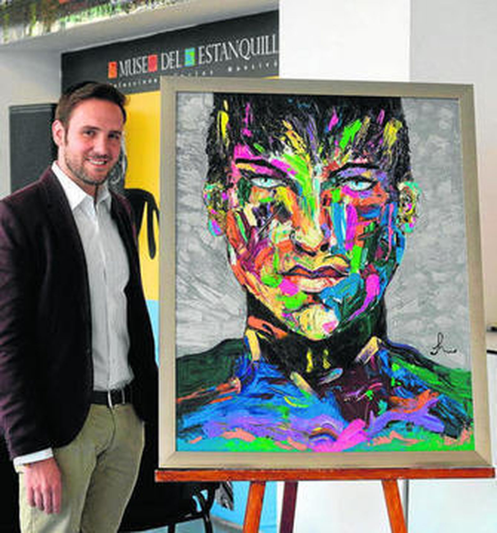 Frank Maldonado con uno de los retratos que expone en México.