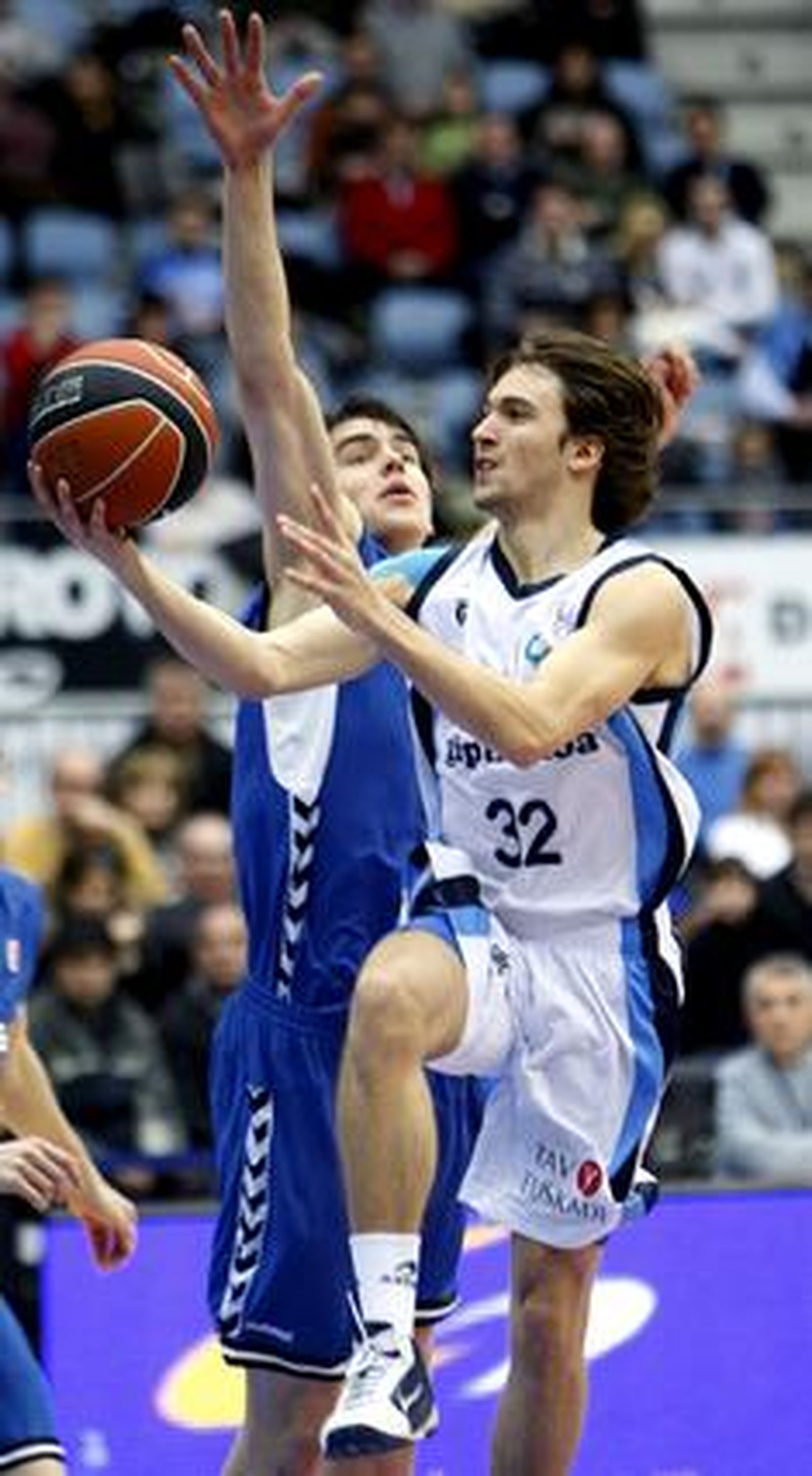 El base del Lagun Aro Rai López entra a canasta ante el alero del Cajasol Joan Sastre.

Foto: Juan Herrero (EFE)