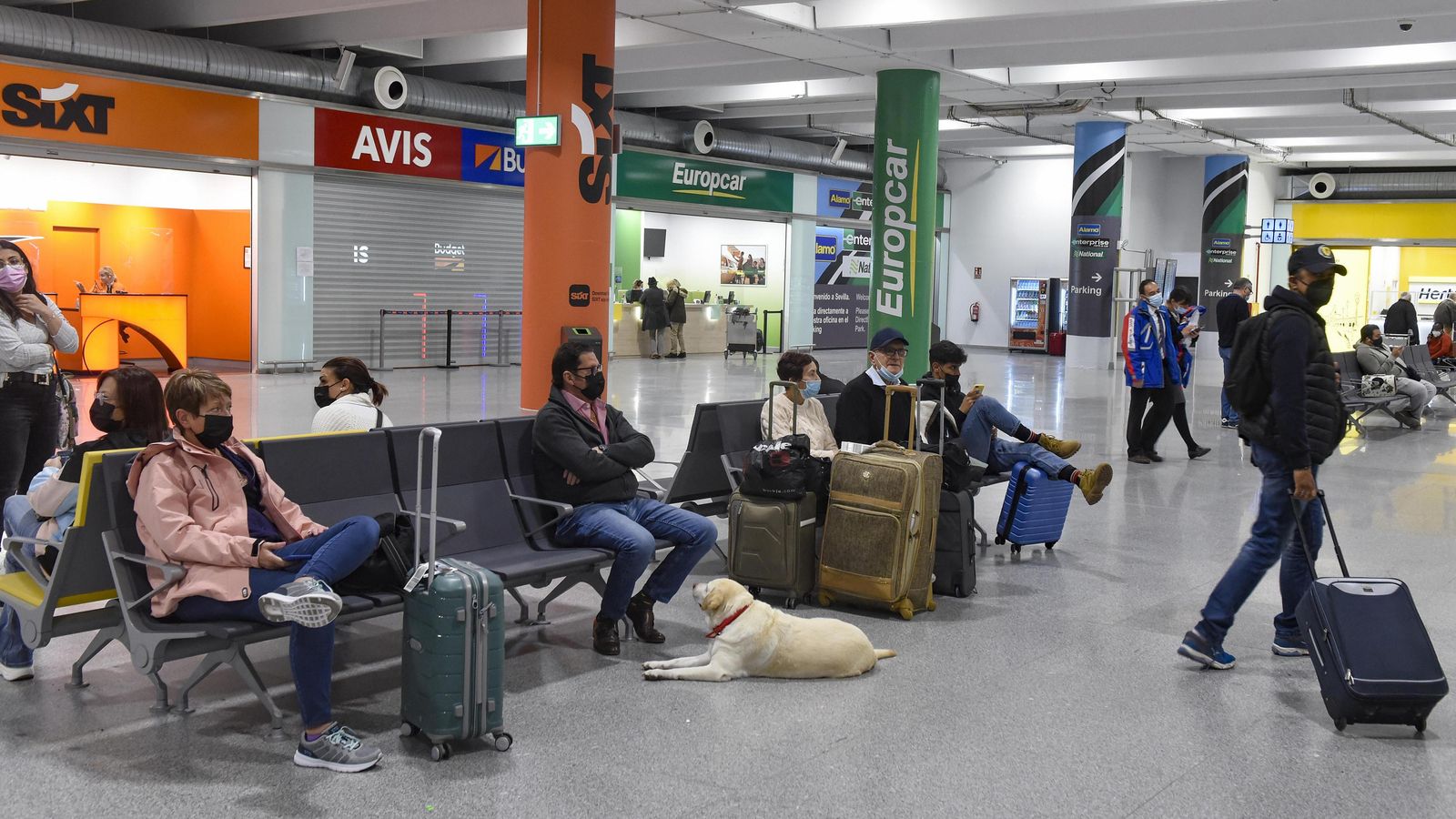 Pasajeros junto a las instalaciones de alquiler de vehículos.