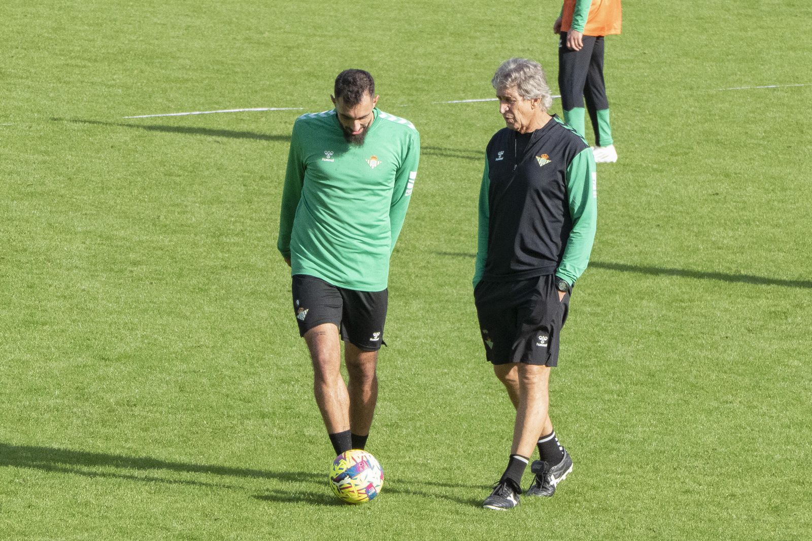 Manuel Pellegrini dialoga con Borja Iglesias, uno de los delanteros verdiblancos, en un entrenamiento.