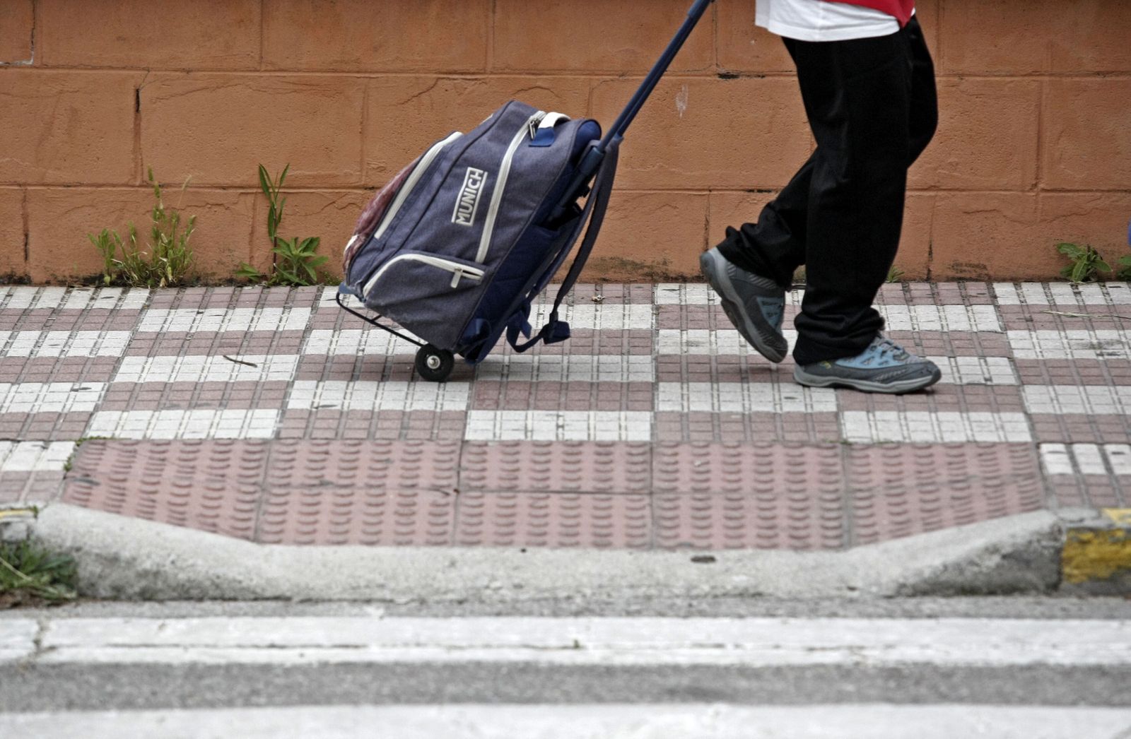 Un niño camina hacia un colegio.