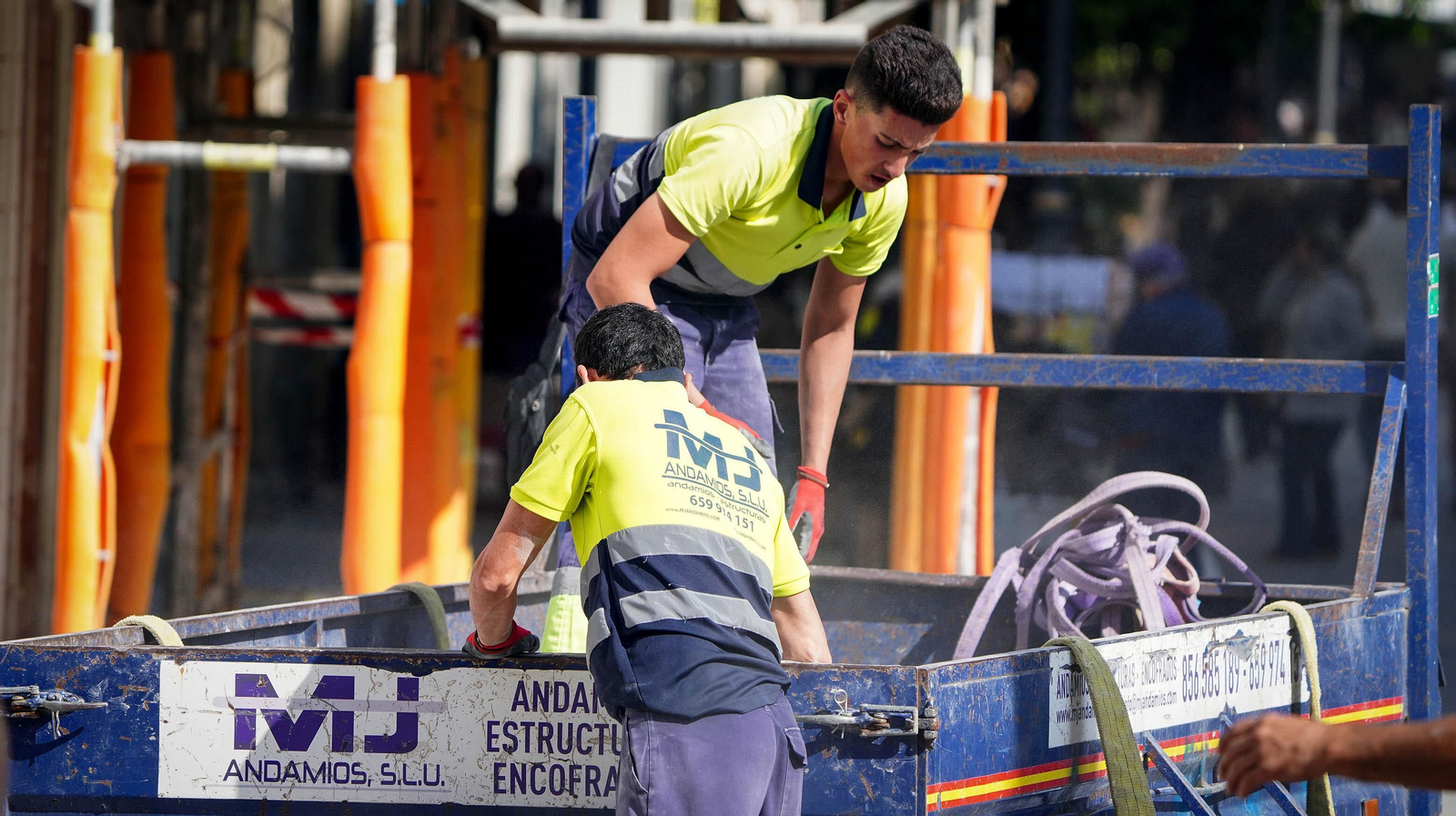Trabajadores del sector de la construcción en el montaje de un andamio.