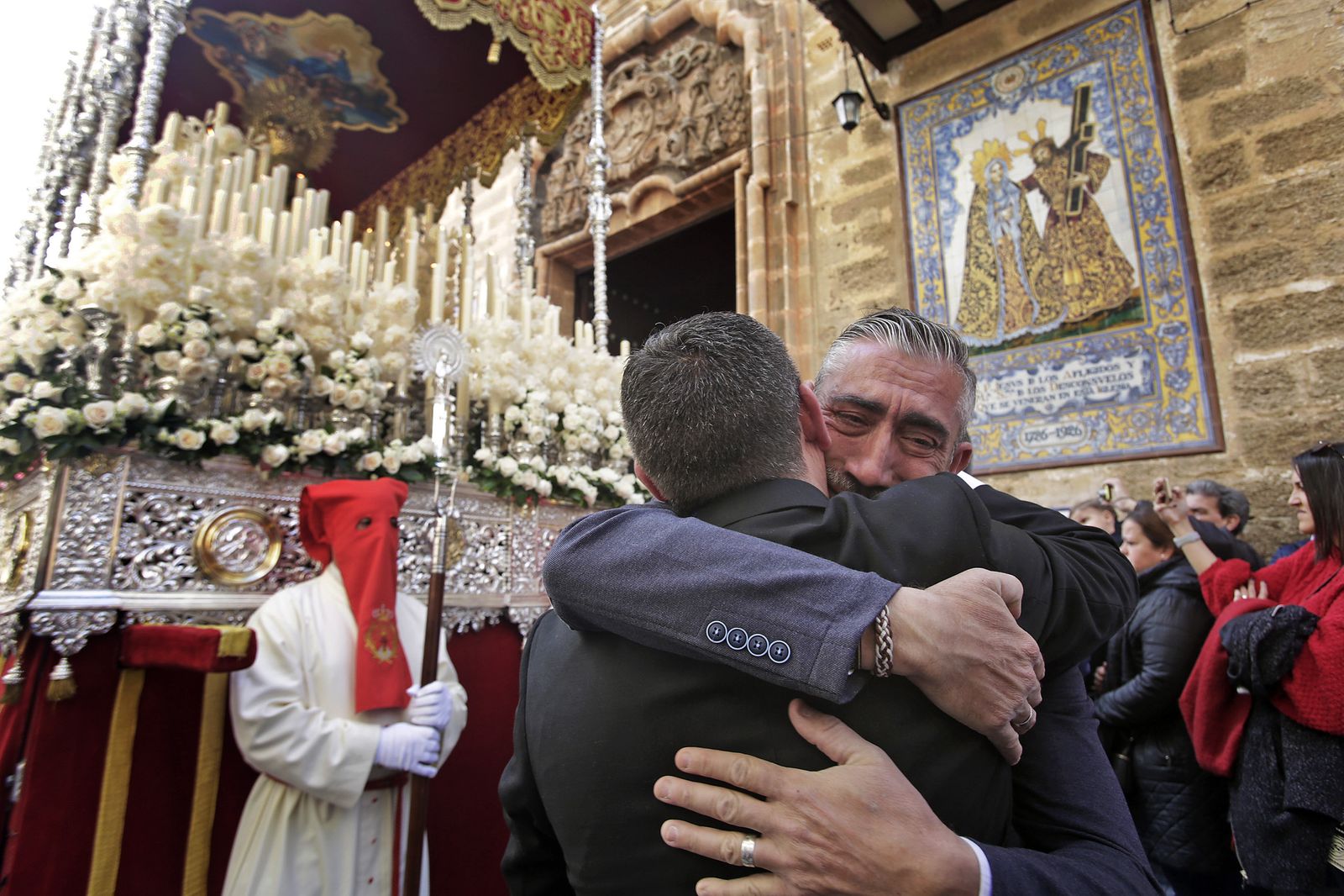 Dos hermanos se abrazan una vez que el palio de Caridad está en Sagasta.