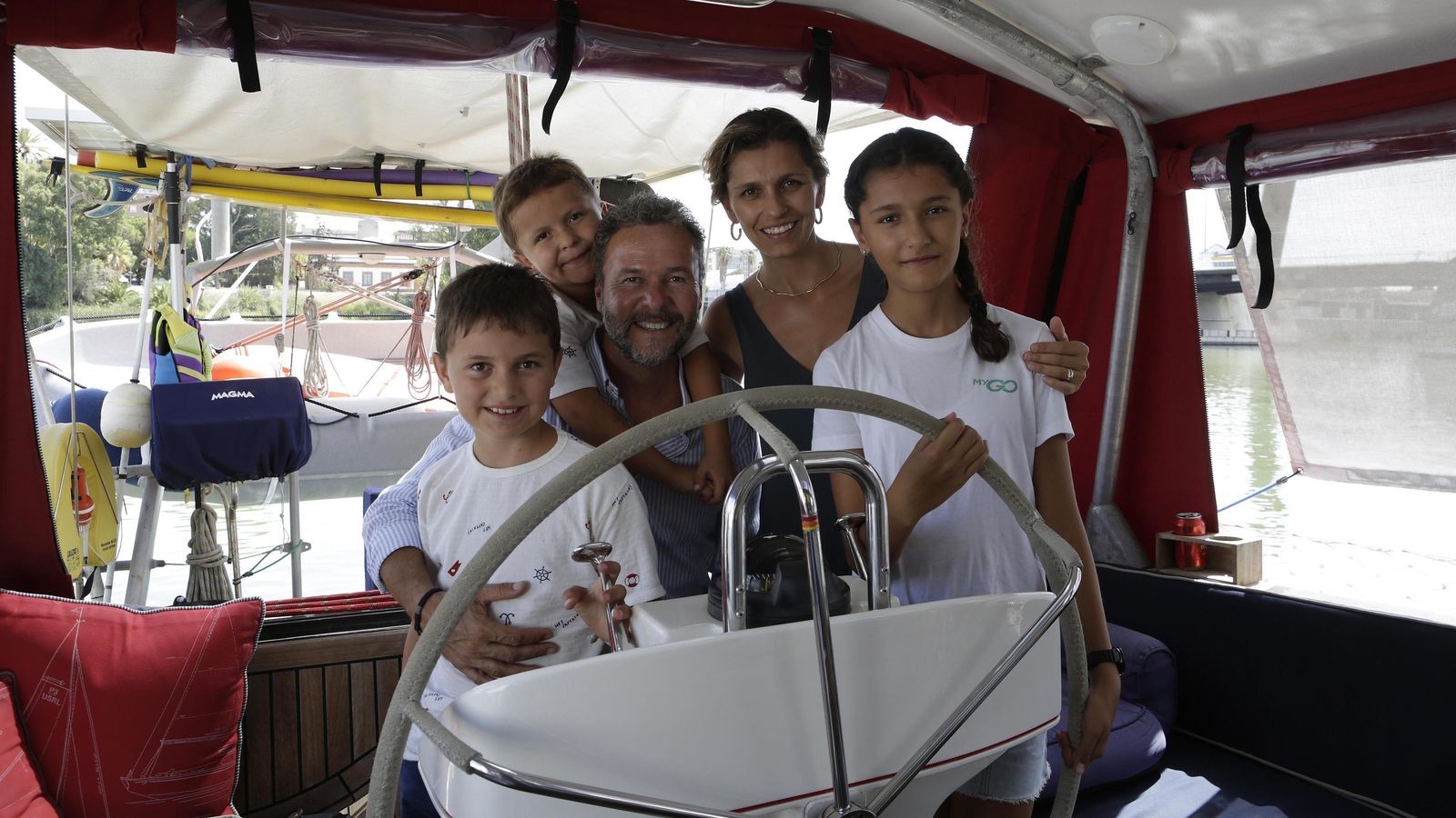 La familia mexicana que está dando la vuelta al mundo en velero posa en el timón del  'Aldivi', atracado en el Club Náutico de Sevilla.