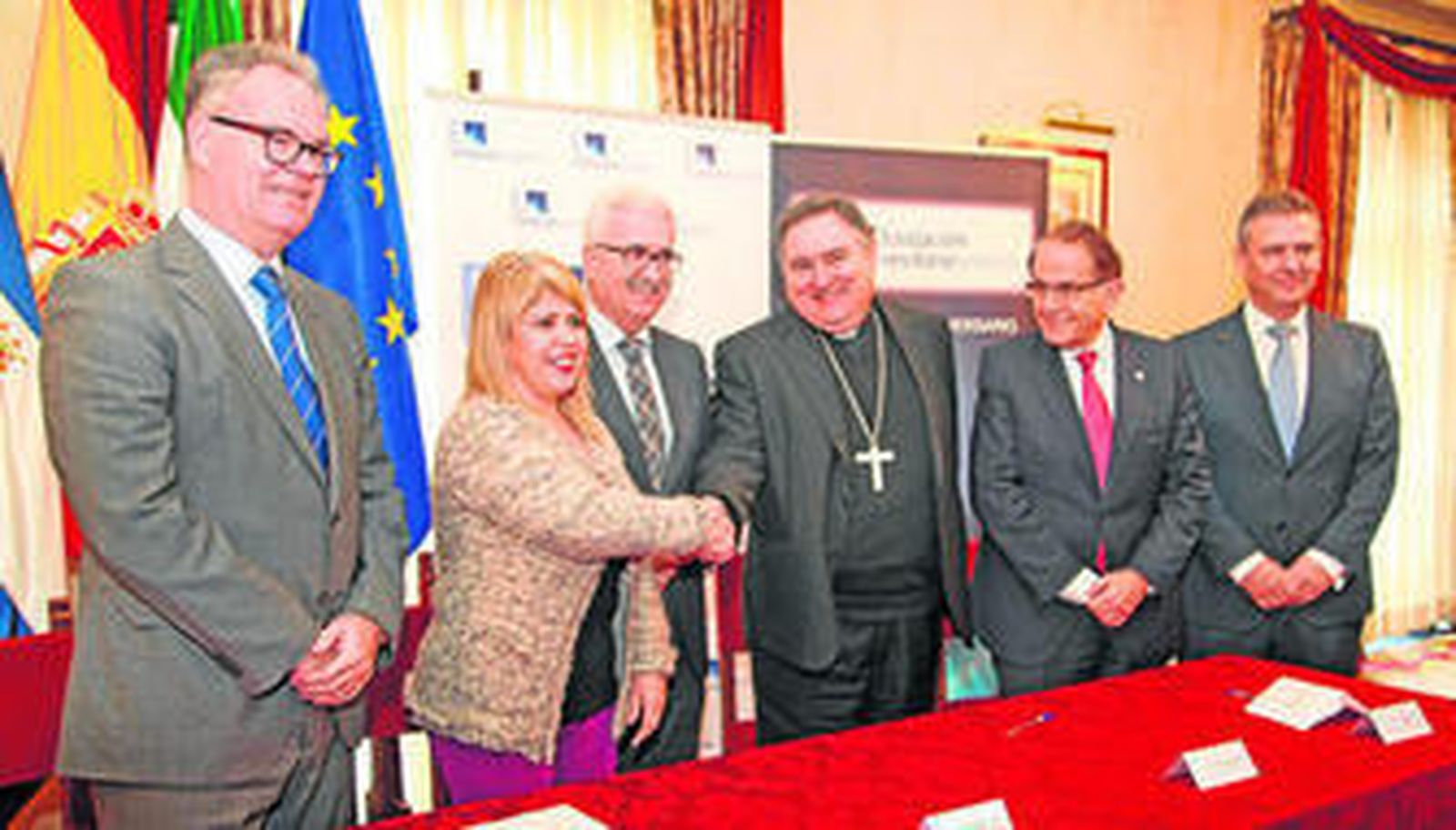 La alcaldesa y el obispo se estrechan la mano tras la firma del convenio, en presencia de Jiménez Barrios y los responsables de las dos fundaciones.